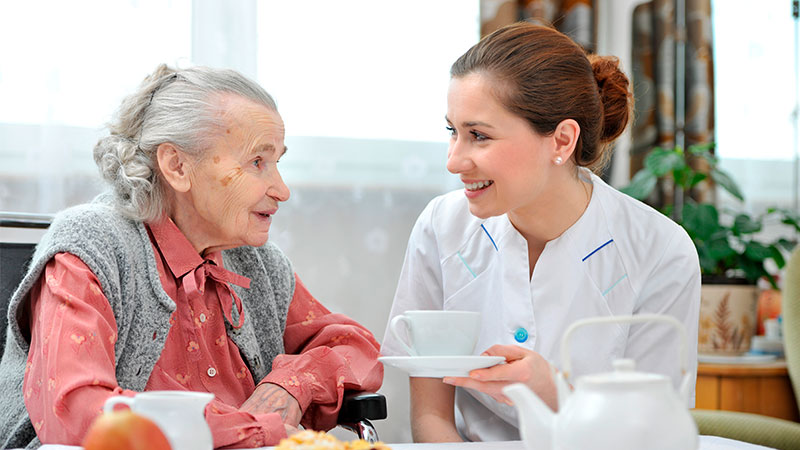 Demenz Seniorin und Pflegerin Essen und Kaffee